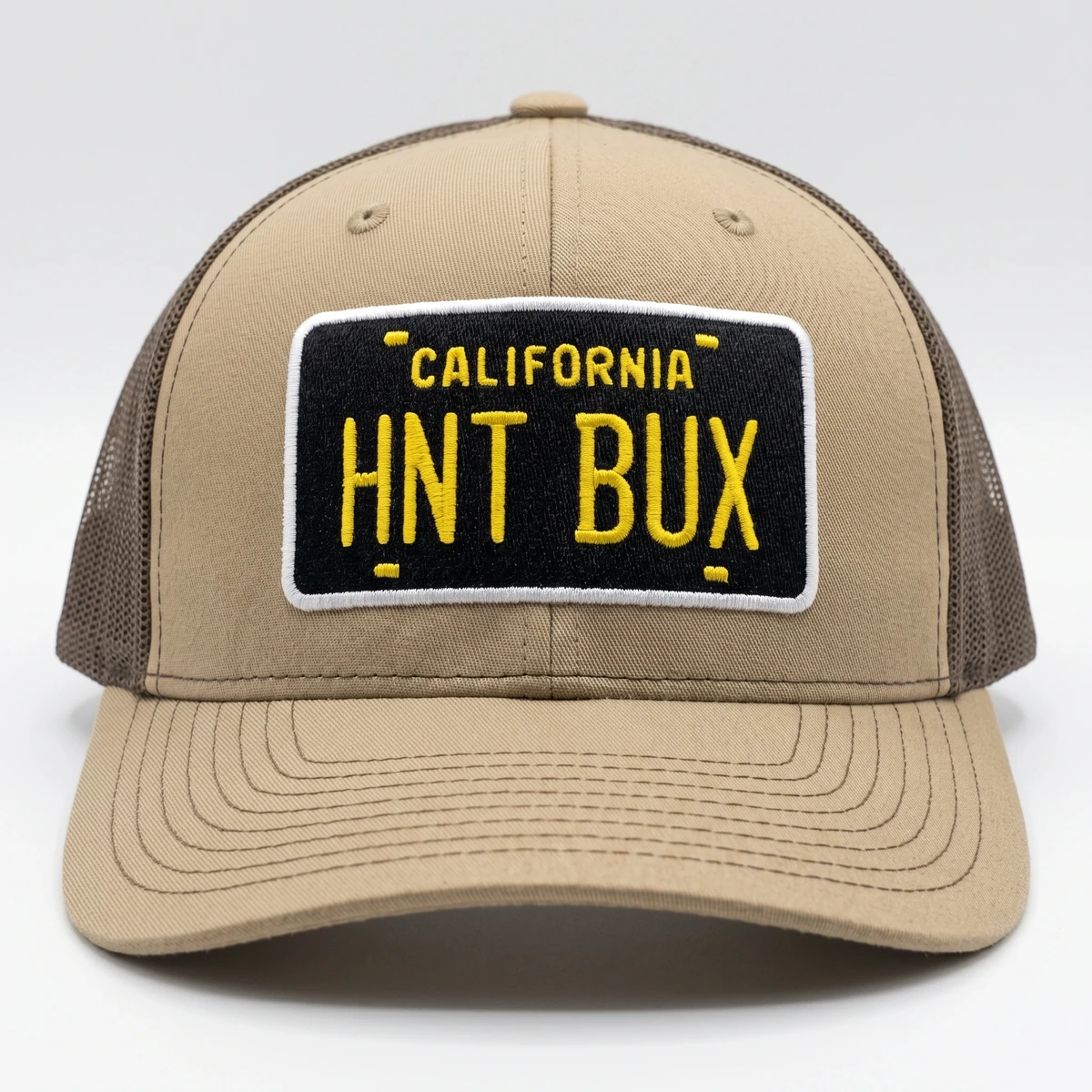 Tan and black California HNT BUX trucker cap with yellow license-plate patch